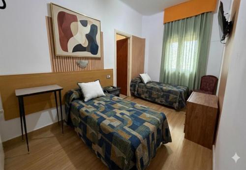 a hotel room with a bed and a chair at Hostal Urgell in Balaguer