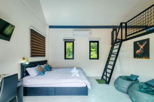 a bedroom with a bed and a spiral staircase at Pool Villa Baan Suan Phrom Khiri in Nakhon Si Thammarat