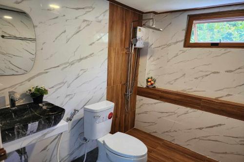 a bathroom with a toilet and a sink at Pool Villa Baan Suan Phrom Khiri in Nakhon Si Thammarat