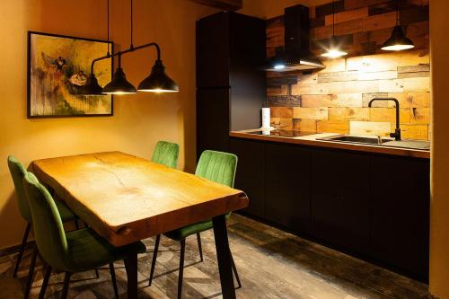 a kitchen with a wooden table and green chairs at Lavender Hill, Eko Resort & Wellness in Polzela