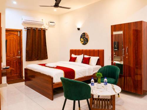 a bedroom with a bed and two chairs and a table at Raja's Paradise Inn in Chennai