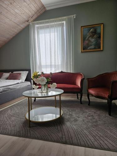 a living room with a couch and a table at Viesu nams AMRAI in Ventspils