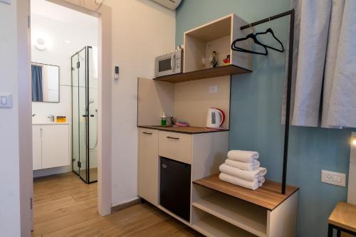 a small bathroom with a sink and a shelf with towels at Shlomtzi Hotel in Jerusalem