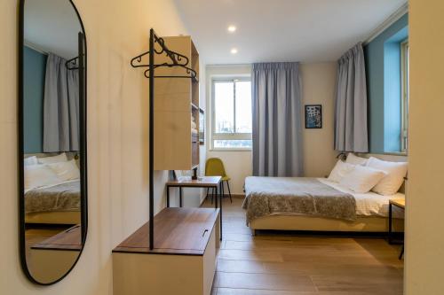 a hotel room with two beds and a mirror at Shlomtzi Hotel in Jerusalem