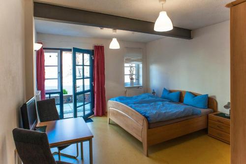 Schlafzimmer mit einem Bett, einem Tisch und einem Schreibtisch in der Unterkunft Hof Märkische Heide in Brandenburg an der Havel
