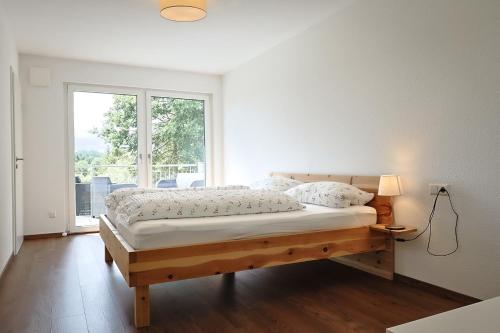 a bedroom with a large bed with a window at Ferienwohnung Bodensee 2 in Meßkirch