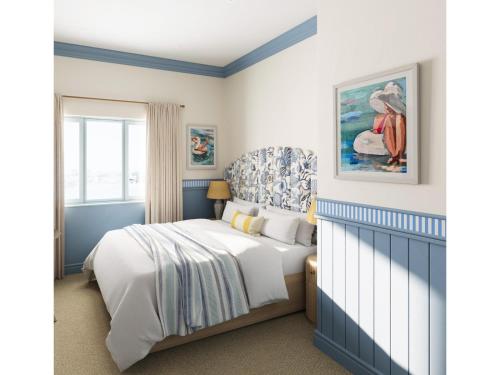 a blue and white bedroom with a bed and a window at Elysium St Mawes in Saint Mawes