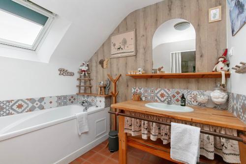 a bathroom with a sink and a tub and a mirror at Gîte - Le Moulin Bernard - Béganne in Béganne