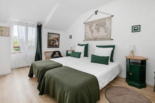 a bedroom with a large bed with green sheets at Gîte - Le Moulin Bernard - Béganne in Béganne