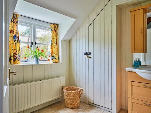 a bathroom with a sink and a window with a plant at Finest Retreats - Coachmans Cottage in Lapford