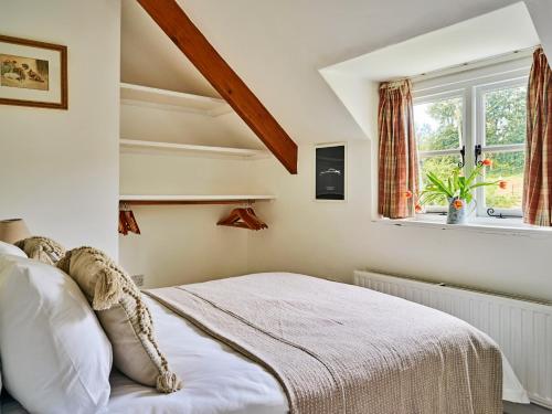 a bedroom with a bed and a window at Finest Retreats - Coachmans Cottage in Lapford