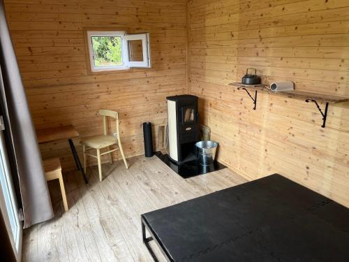 a room with a stove and a chair in a cabin at Samoobslužná maringotka in Žihobce