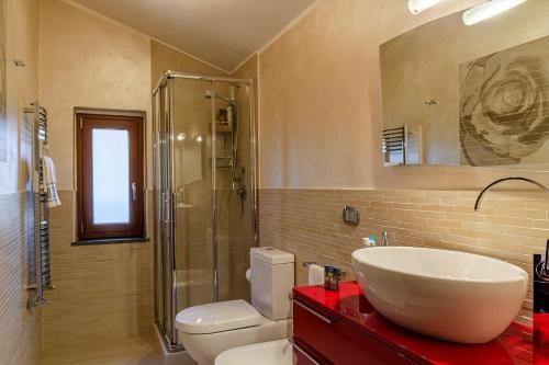 a bathroom with a sink and a toilet and a shower at Villa Corte Fiorita in Aci SantʼAntonio