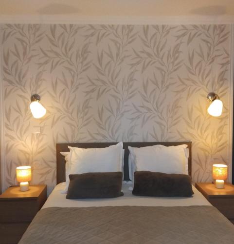a bedroom with a bed with two lights on the wall at la grange du coudert in Saint-Cybranet