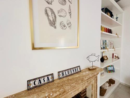 a fireplace in a living room with a picture on the wall at Casa Bluende in Novo Sancti Petri
