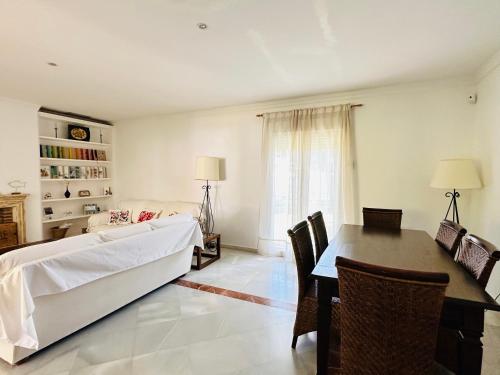 a living room with a bed and a dining room table at Casa Bluende in Novo Sancti Petri