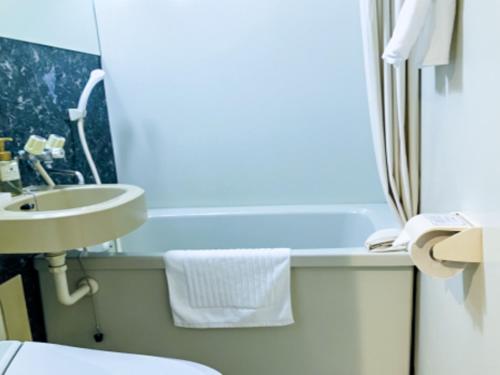 a small bathroom with a sink and a toilet at HOTEL LiVEMAX BUDGET Nippori in Tokyo