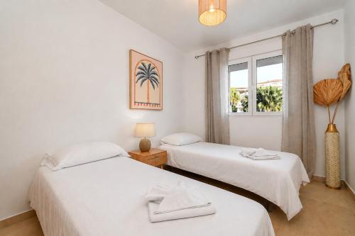 two beds in a room with a window at Apartment Happy Coast Moraira in Moraira