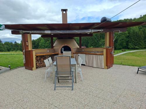 a pavilion with a table and chairs and a grill at House Gore VVV in Dol pri Hrastniku