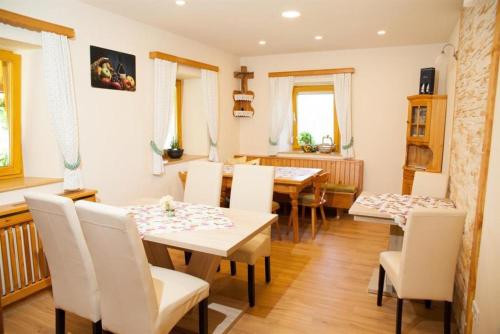 a dining room with a table and white chairs at Obst- und Weinbauernhof BERNHARD in Leutschach