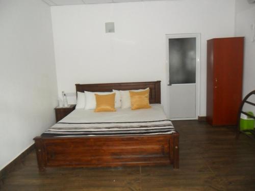 a bed with orange and white pillows in a room at river edge bungalow in Matale