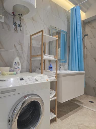 a bathroom with a washing machine and a sink at Teal Apartment in Draç