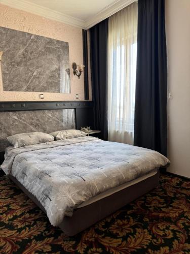 a bedroom with a bed and a large window at Antik Otel in Ankara