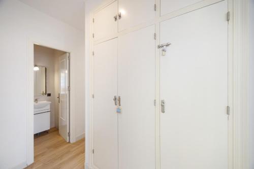 a bathroom with white cabinets in a white room at Casapoley Vejer in Vejer de la Frontera