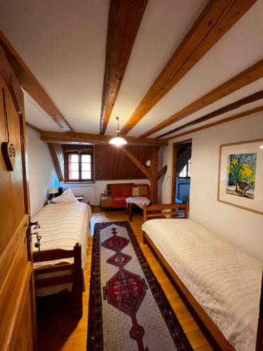 a bedroom with two beds and a living room at Skansen Gottwaldówka in Kąty Bystrzyckie