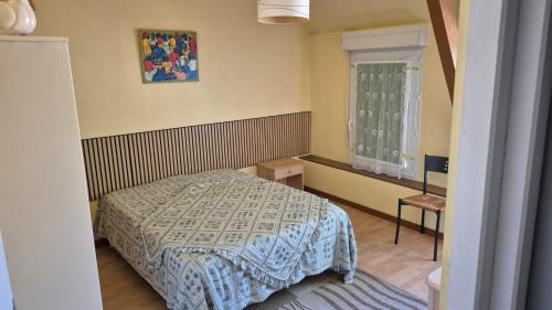 a small bedroom with a bed and a window at Biloba in Saint-Paul-lès-Dax