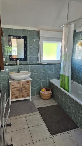 a bathroom with a sink and a tub and a mirror at Biloba in Saint-Paul-lès-Dax