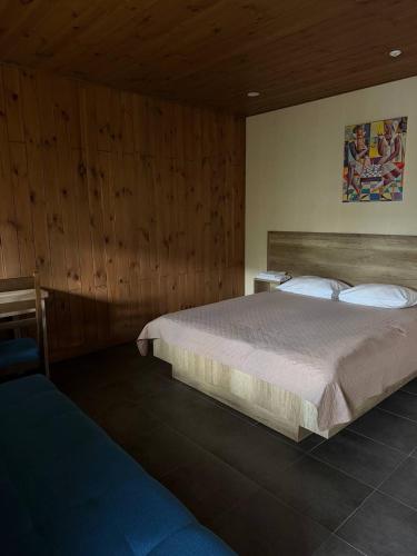 a bedroom with a large bed and wooden walls at Хутір Hall in Radisne
