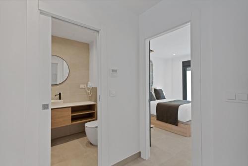 a bedroom with a bed and a toilet and a mirror at GAV Nueva Quince in Ronda