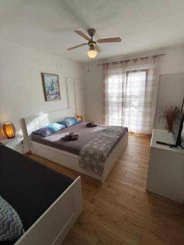 a bedroom with a bed and a ceiling fan at Apartment Miljenko Tomic 2 in Supetar