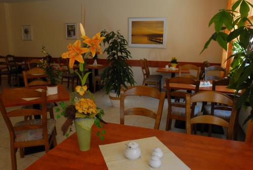 a restaurant with tables and chairs with flowers on them at Hotel Am Pan in Emmerich