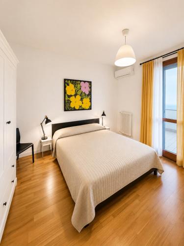 a bedroom with a large bed and a window at Galleria Massimo Trilocale Frontemare - Agenzia Cocal in Caorle