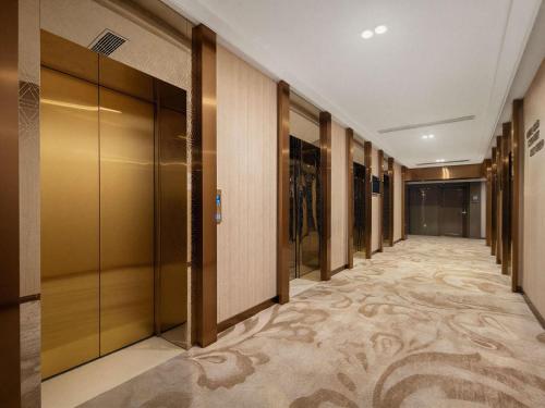 a corridor of a hotel with wooden doors and a walk in closet at Mercure Chongqing Downtown in Chongqing