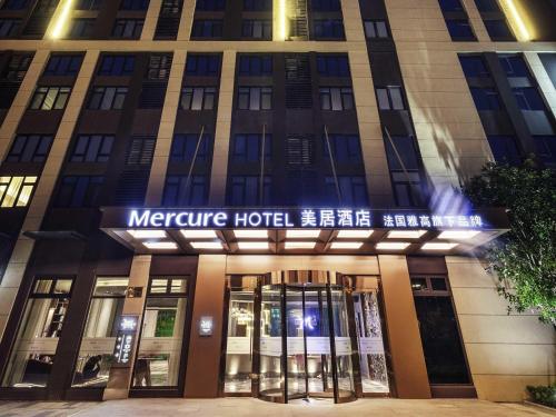 a building with a sign on the front of it at Mercure Shanghai Jiuting in Shang-hai