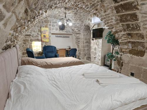 a bedroom with two beds in a stone wall at Gılgamesh Maria butik otel in Mardin