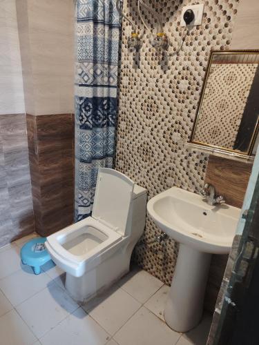 a bathroom with a toilet and a sink at New Vybent Hotel Kainchi Dham in Bhowāli