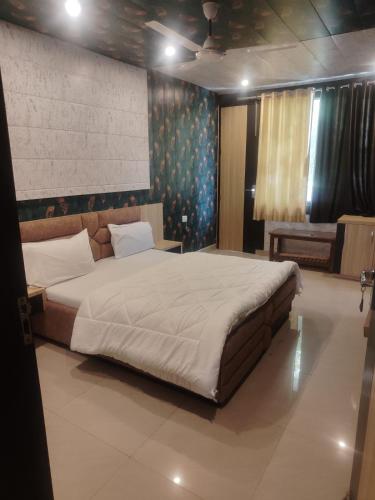 a bedroom with a large bed in a room at New Vybent Hotel Kainchi Dham in Bhowāli