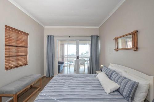 a bedroom with a bed and a window at Rabe's Rest in Yzerfontein