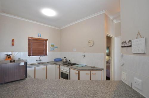 a kitchen with a sink and a stove at Rabe's Rest in Yzerfontein