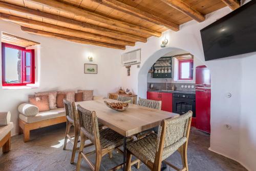 a kitchen and dining room with a wooden table and chairs at Marketos Traditional Windmill in Tripiti