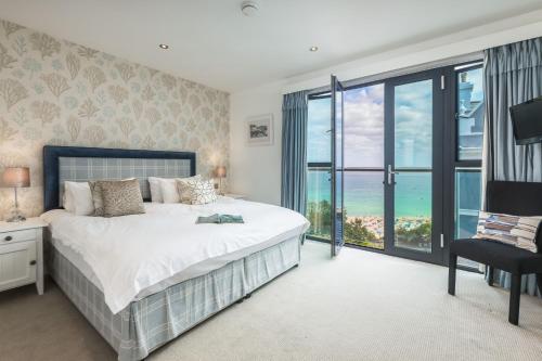 a bedroom with a bed and a view of the ocean at Porthminster Mews 2 in St Ives