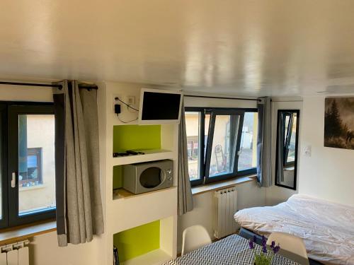 a small room with a bed and a tv at Studio vieille porte in Hombourg-Haut