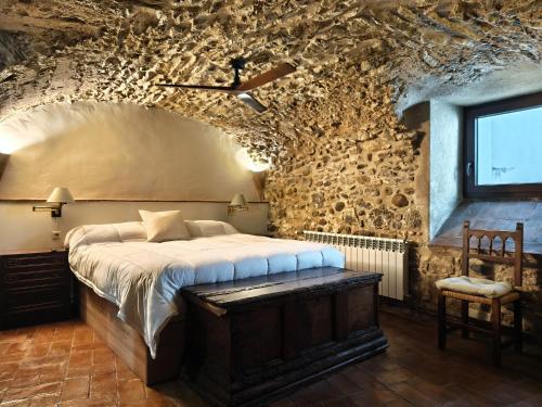 a bedroom with a large bed in a stone wall at Casa historica en Corçà, Baix Empordà in Corçà