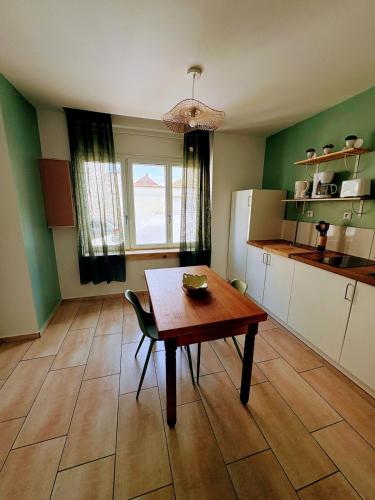 a kitchen with a wooden table and a dining room at Le Temps d une Pause in Calais