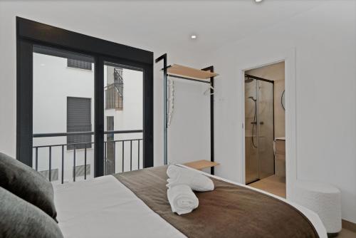 a bedroom with a bed and a large window at GAV Nueva Quince in Ronda