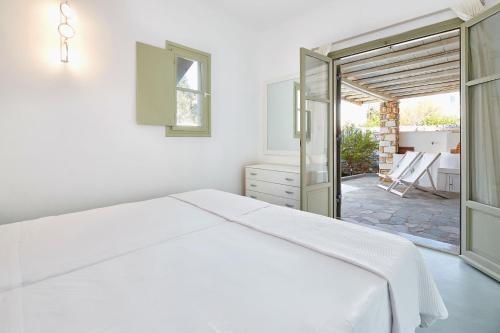 a white bedroom with a bed and a patio at Villa Joy in Aliki